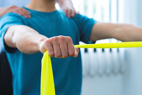 Person stretching exercise band between their hands Person stretching exercise band between their hands